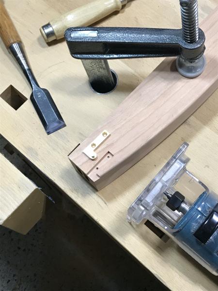 Detail shot of router and chisel used to cut a hinge mortise.